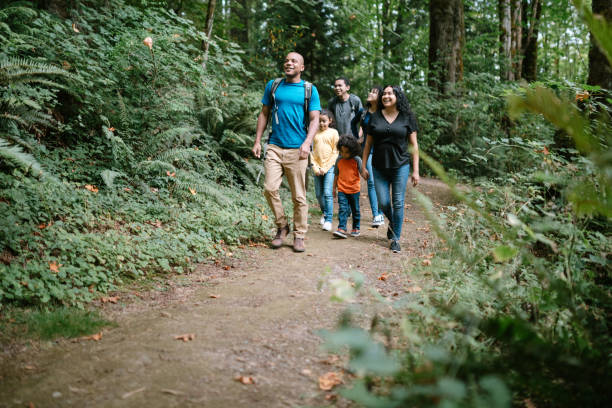 Family Enjoying Hike On Forest Trail in Pacific Northwest A young mixed race family spends time together outside in Washington state, enjoying the beauty of the woods in the PNW. trail stock pictures, royalty-free photos & images