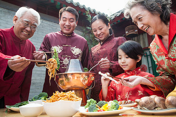 Family enjoying meal in traditional Chinese clothing stock photo