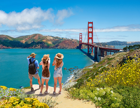 People enjoying time together on vacation hiking trip.  Golden Gate Bridge, over Pacific Ocean, mountains in the background. San Francisco, California, USA