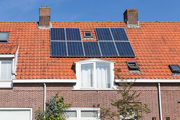 einfamilienhaus mit solarpanel auf dem dach - dachfenster stadt stock-fotos und bilder