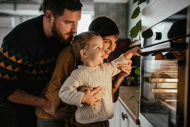 Family is waiting for meal to be done Young family with son is looking in the oven and waiting for their meal to be done. oven stock pictures, royalty-free photos & images