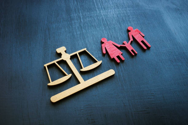 Family law concept. Figures of scales and families for adoption. stock photo