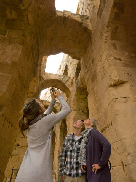 Family looks up and takes photo of ancient archways El Jem/El Djem, Mahdia Governorate tunisian girls stock pictures, royalty-free photos & images