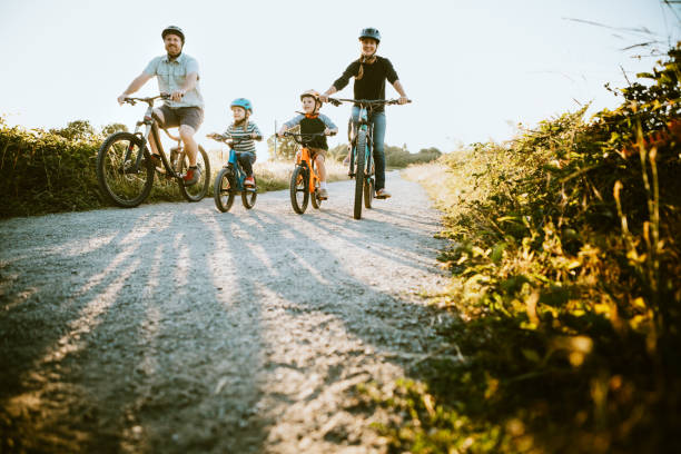 Family Mountain Bike Riding Together on Sunny Day A father and mother ride mountain bikes together with their two small children.  A fun way to spend time together and exercise while on vacation in the Seattle, Washington area. activity stock pictures, royalty-free photos & images