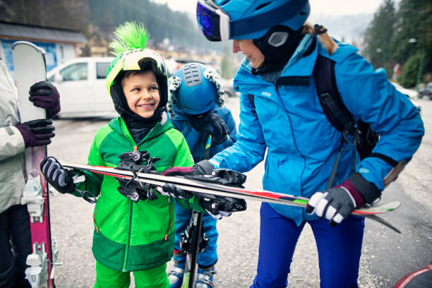 familie packt skiausrüstung nach dem skifahren ans auto - auto packen für den urlaub winter stock-fotos und bilder