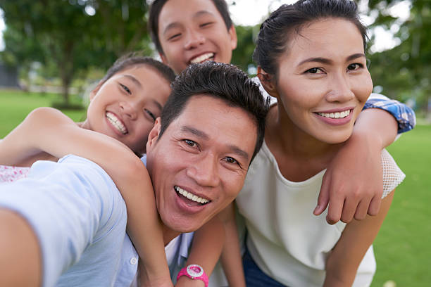 Family photo Happy Vietnamese family hugging when photographing together east asian ethnicity stock pictures, royalty-free photos & images
