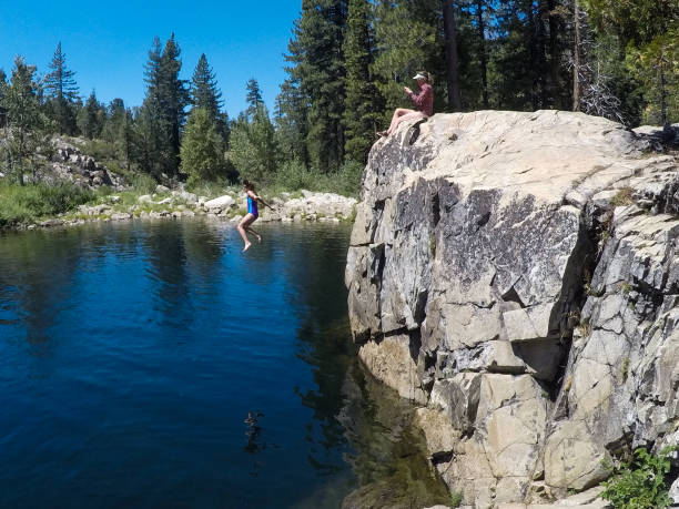 Family playing and exploring all the beauty of Lake Tahoe Family with young children go cliff jumping on the South Yuba River in California cliff jumping stock pictures, royalty-free photos & images
