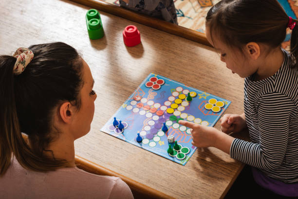 Family playing board game at home. Mother and daughter playing board game at home. board game photos stock pictures, royalty-free photos & images