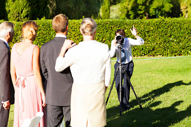 famille posant tout homme prendre une photo de leur mariage dans le jardin - photographe mariage photos et images de collection