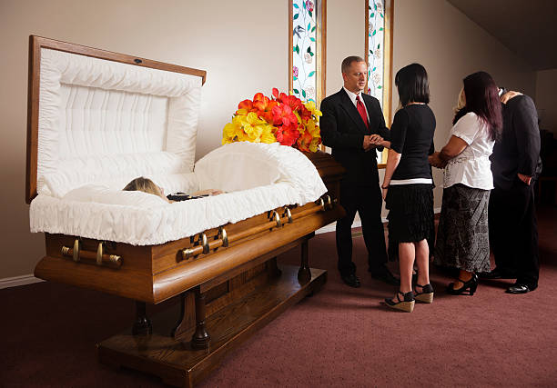 Family Receiving Guests at a Funeral A receiving line of guests next to the casket at a funeral in a funeral home. funeral parlor stock pictures, royalty-free photos & images