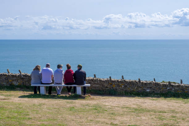Family resting and admiring the seascape on the cliff of Cape Carteret. Barneville-Carteret, Normandy, France Normandy, France - August 25, 2018: Family resting and admiring the seascape on the cliff of Cape Carteret. Barneville-Carteret, Normandy, France barneville carteret photos stock pictures, royalty-free photos & images