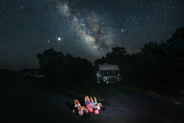 RV Family Road Trip Family lies on the ground by RV looking at the stars astronomy stock pictures, royalty-free photos & images