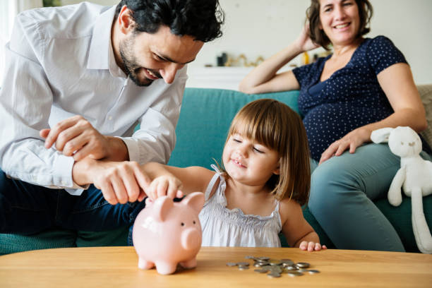 family saving money in piggy bank - change habits imagens e fotografias de stock