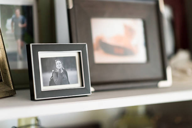 Family Snapshots Framed on Shelf Family Snapshots Framed on Shelf cabinet photos stock pictures, royalty-free photos & images