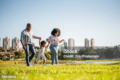 istock Family strolling in the late afternoon in the city park 1355338628