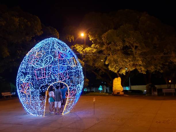 Family takes a selfie inside a giant egg decorated with Christmas lights. stock photo