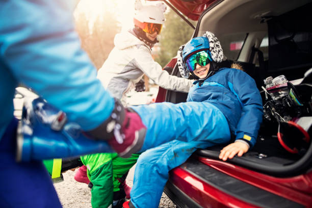 familie ausziehen skischuhe nach dem skifahren - auto packen für den urlaub winter stock-fotos und bilder
