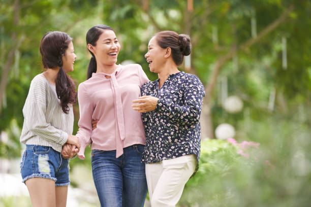 Family walk Vietnamese teen girl with mother and grandmother walking outdoors and laughing asian mother talking with daughter stock pictures, royalty-free photos & images