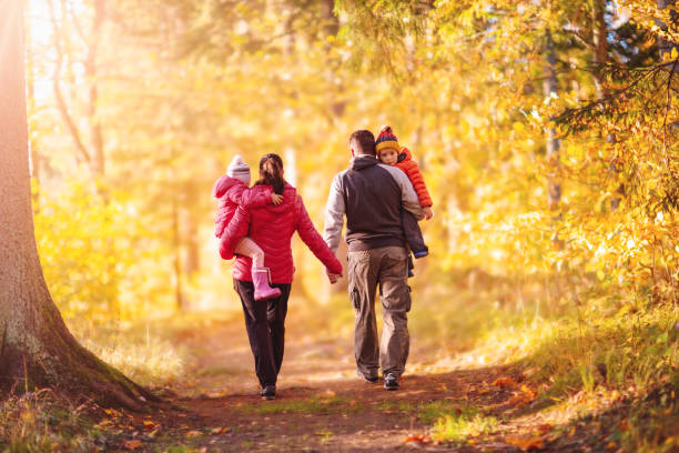 Family walking along the footpath in the autumnal natural park stock photo