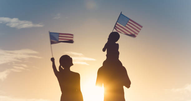 Family waving American flags Patriotic silhouette of family waving American USA flags. 4th of july stock pictures, royalty-free photos & images