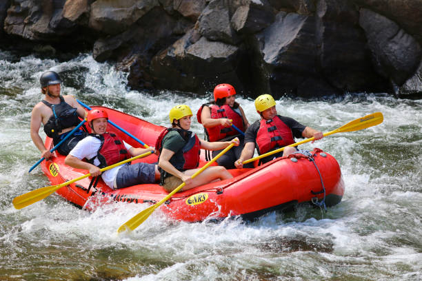 Family white water rafting Clear Creek Idago Springs, Colorado August 10, 2016 A pretty woman and family raft with guide on rapids on Clear Creek Canyon in Idaho Springs, just outside of Denver, Colorado. inflatable raft stock pictures, royalty-free photos & images