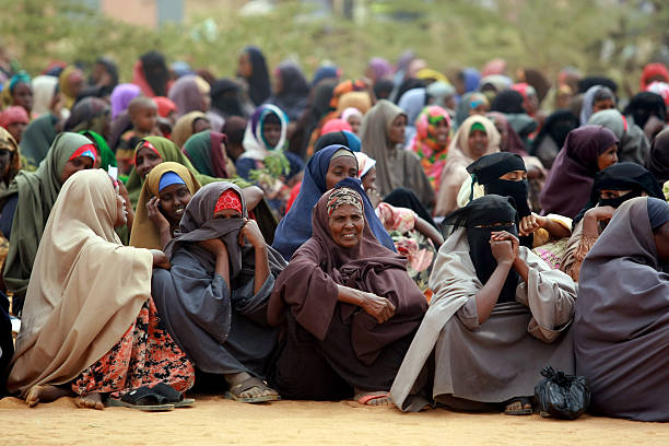 Famine in Africa Dadaab Refugee Camp Dadaab, Kenya - August 14, 2011: A newly arrived Somali refugees waits following their registration and food on August 14, 2011 at the Dadaab refuge complex. UN Under-Secretary-General for Humanitarian Affairs and Emergency Relief Coordinator Valerie Amos toured today the refuge complex holding more that 440,000 refugees during the third day of her visit to southern Somalia and to the Kenya-hosted refugee complex to asses the impact of the famine. Her visit comes as the UN said its moving on two fronts to counter the worsening food crisis in the Horn of Africa, with an immediate infusion of food in an area where 640,000 children alone are threatened with acute malnutrition. african immigrant stock pictures, royalty-free photos & images