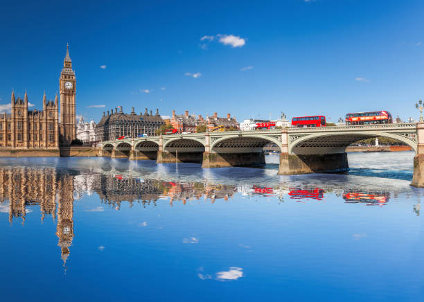 Famous Big Ben with red buses on bridge over Thames river in London, England, UK stock photo