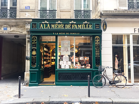Facade of famous artisan chocolate shop in Paris close to Saint Germain des Pres boulevard. Green historical vintage facade.