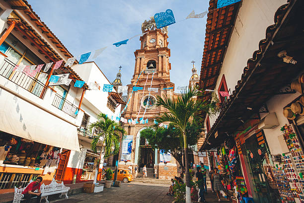 Famous church in Mexico Puerto Vallarta, Mexico - December 28, 2016: Our Lady of Guadalupe Parish sits on a busy street filled with tourists and souvenir vendors. puerto vallarta stock pictures, royalty-free photos & images
