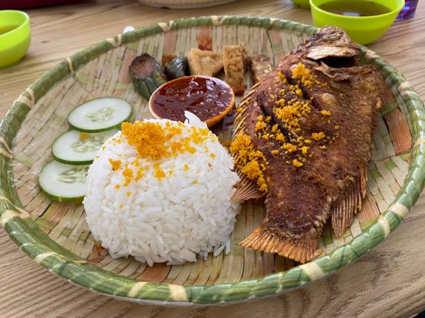 Famous traditional Indonesian food. Delicious nasi ikan penyet with sambal belacan. Fresh hot with steam smoke. Famous traditional Indonesian food. Delicious nasi ikan penyet with sambal belacan. Fresh hot with steam smoke. ikan stock pictures, royalty-free photos & images