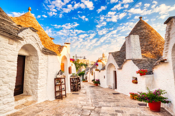 Famous Trulli Houses during a Sunny Day with Bright Blue Sky in Alberobello, Puglia, Italy stock photo