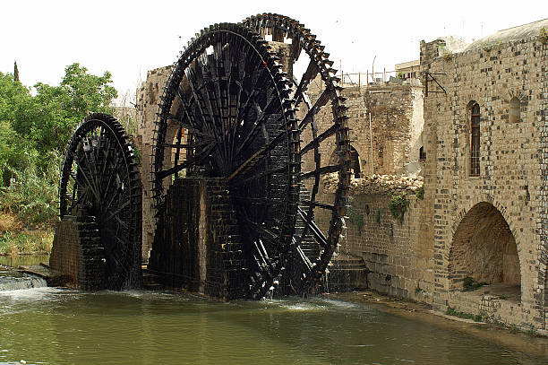 Famous wooden waterwheels in Hama in Syria Huge wooden waterwheels transported water from river Orontes to Hama in Syria water wheel stock pictures, royalty-free photos & images