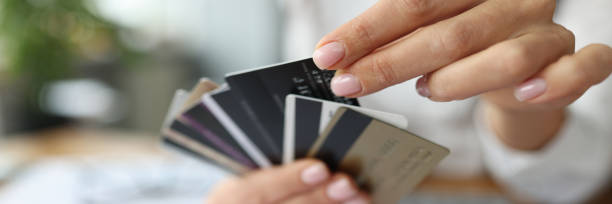 fan of plastic credit cards is in woman's hand. - credit card imagens e fotografias de stock