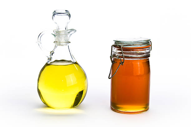 Fancy glass containers of oil and honey on isolating background stock photo