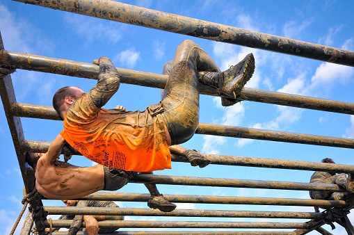 Gijon, Spain - January 31, 2016: Farinato Race, extreme obstacle race in January 31, 2016 in Gijon, Spain. People jumping, crawling,passing under a barbed wires or climbing obstacles during extreme obstacle race. 