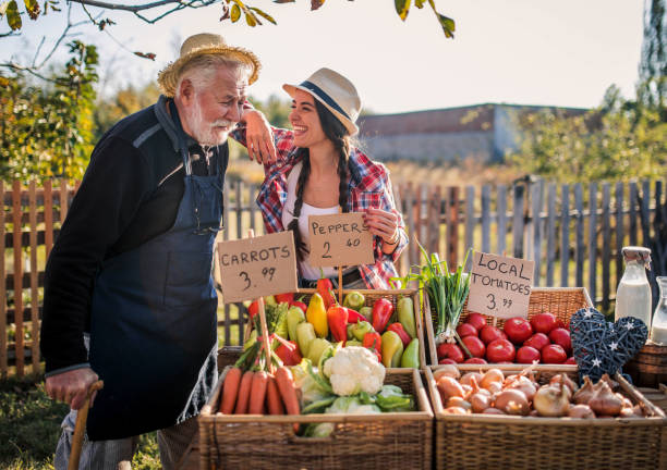 Farm workers  selling homegrown groceries on a market stand stock photo