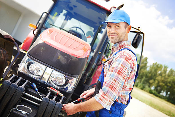 Farmer repairing his big tractor  agricultural machinery stock pictures, royalty-free photos & images