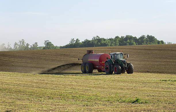 Farmer Spreading Liquid Manure Elmira, Ontario, Canada - June 1, 2016: Two tractors spreading liquid manure on a late spring day in Southwestern Ontario. spreading fertilizer stock pictures, royalty-free photos & images