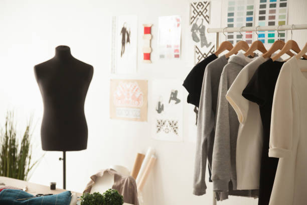 Fashion design cozy studio interior with dummy, dressmaking and Fashion creative design studio cozy interior concept with mannequin dummy and exclusive unique stylish fashionable trendy clothes on hangers, dressmaking workplace, tailor shop, sewing workshop womenswear stock pictures, royalty-free photos & images