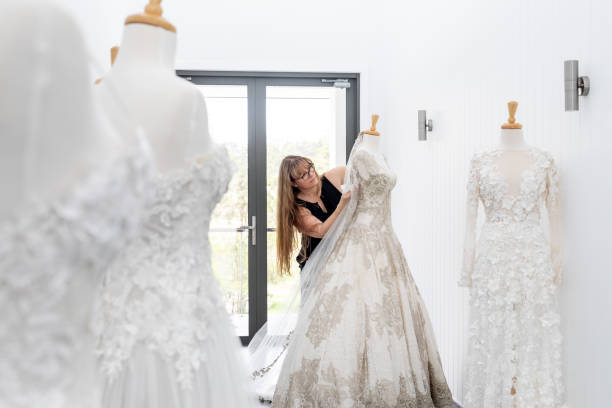 Fashion Designer Working On Couture Bridal Gown On Mannequin stock photo