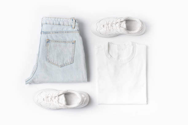 moda abiti femminili su sfondo bianco. t shirt basic e jeans e sneakers in denim. - shoes top view foto e immagini stock