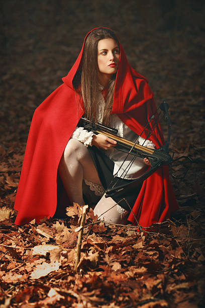 Fashion little red riding hood posing in the forest stock photo