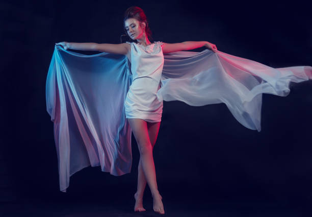 Fashion portrait of young elegant girl in white dress. Black background, studio shot. Fashion portrait of young elegant girl in white dress. Black background, studio shot. Beautiful woman with red and blue. girl in neon. shooting in Asian style angel 13 stock pictures, royalty-free photos & images