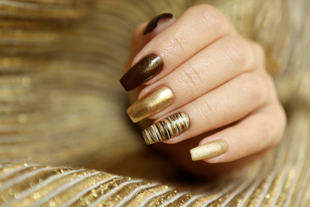Fashionable manicure . Fashionable manicure with a matte Golden color of nail Polish and brown on a long nail shape. nail strips stock pictures, royalty-free photos & images
