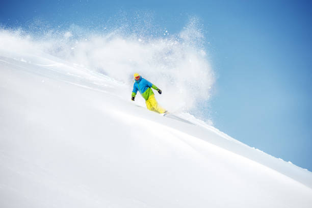 Fast snowboarder at off-piste with powder Fast snowboarder at off-piste slope with powder snow tail. Freeride ski concept powder mountain stock pictures, royalty-free photos & images