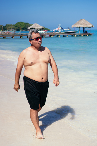 fat man walking on the beach