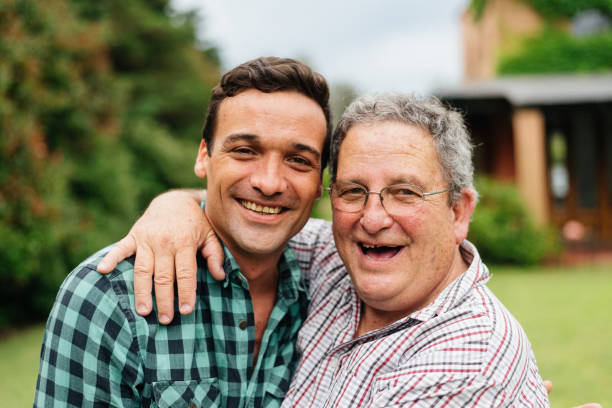 Father and adult son celebrating in their backyard Father and adult son celebrating in their backyard fathers day stock pictures, royalty-free photos & images