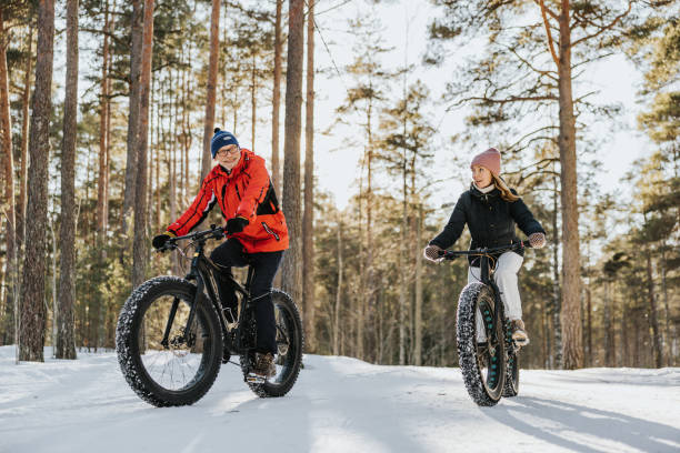 Father and daughter fatbiking in nature stock photo