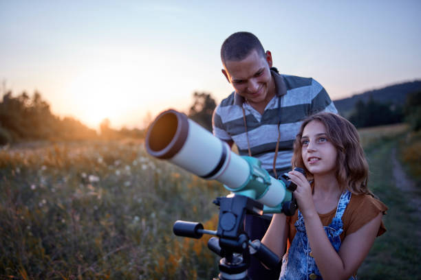 vader en dochter observeren de hemel met een telescoop. - astronomie stockfoto's en -beelden