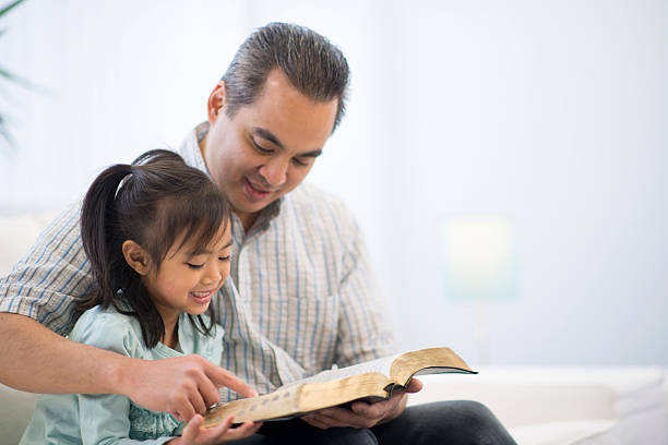 father and daughter reading a bible together - home office bildbanksfoton och bilder